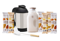 The Almond Cow Milk Maker with Glass Jug and Cleaning Brush surrounded by Almond 'n' Dates and Creamy CocoCash Milk Medleys