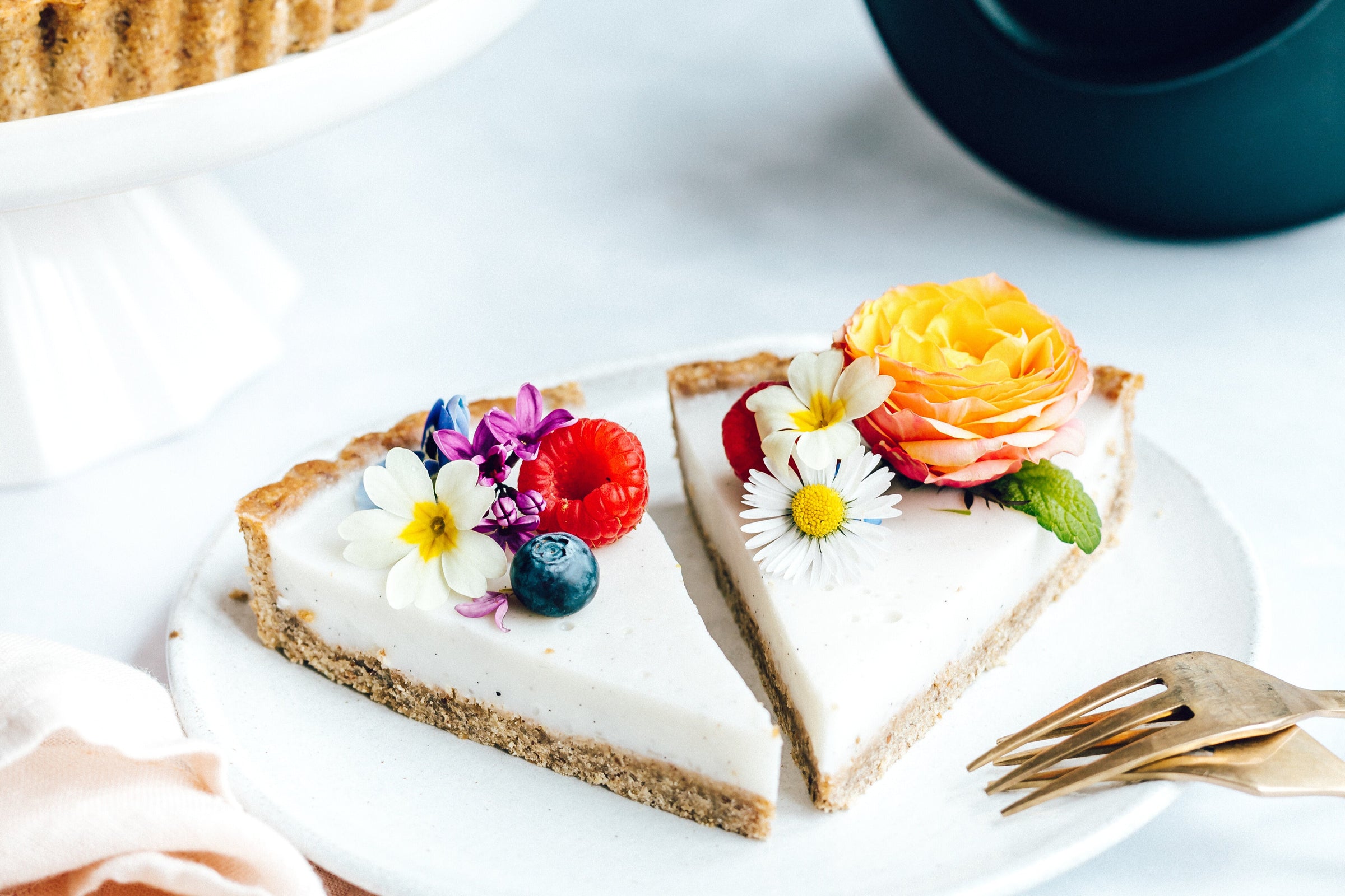 a tart topped with flowery accents on top. An Almond Cow machine lays on its side in the background.
