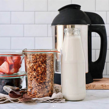 almond coconut granola in a jar next to a jug of milk