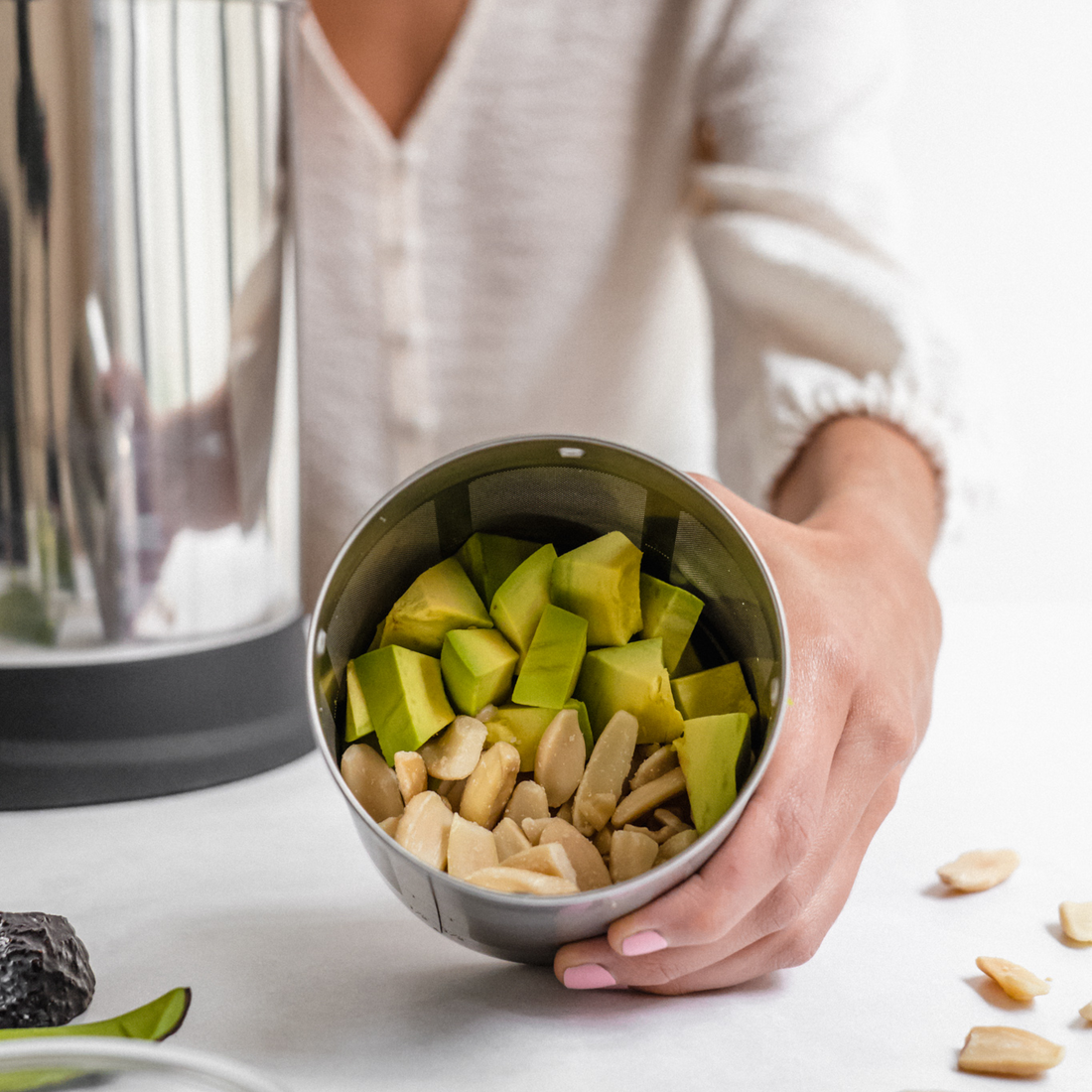 vegan avocado pili nut plant-based milk being poured into a glass bottle