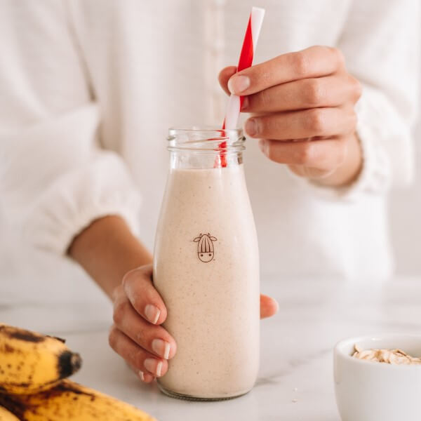vegan banana bread smoothie in a almond cow bottle with a straw