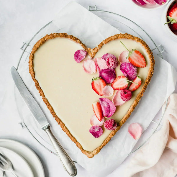 Almond Cow's Berry Rose White Chocolate Tart with candied rose petals and sliced strawberries.