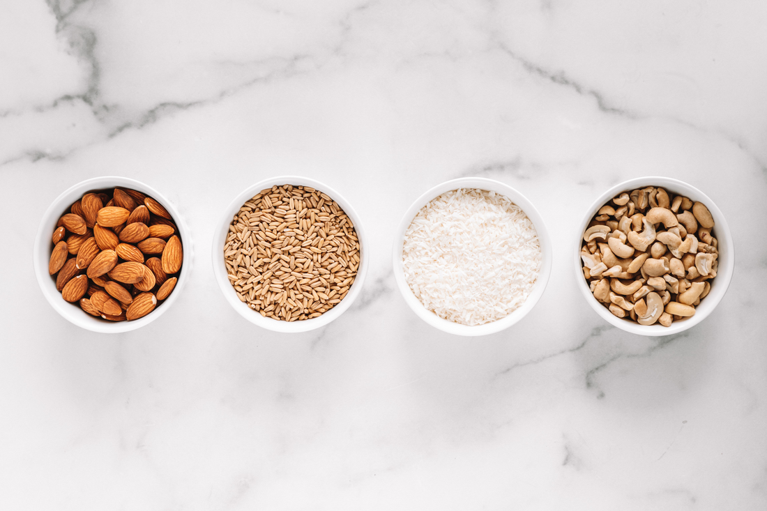 bowls of Almond Cow Ingredients: Almonds, Whole Grain Oats, Coconut shreds, and Cashew Pieces.