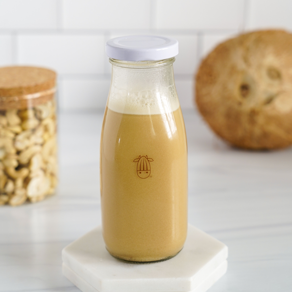 vegan, plant-based caramel creamer in an almond cow glass bottle 