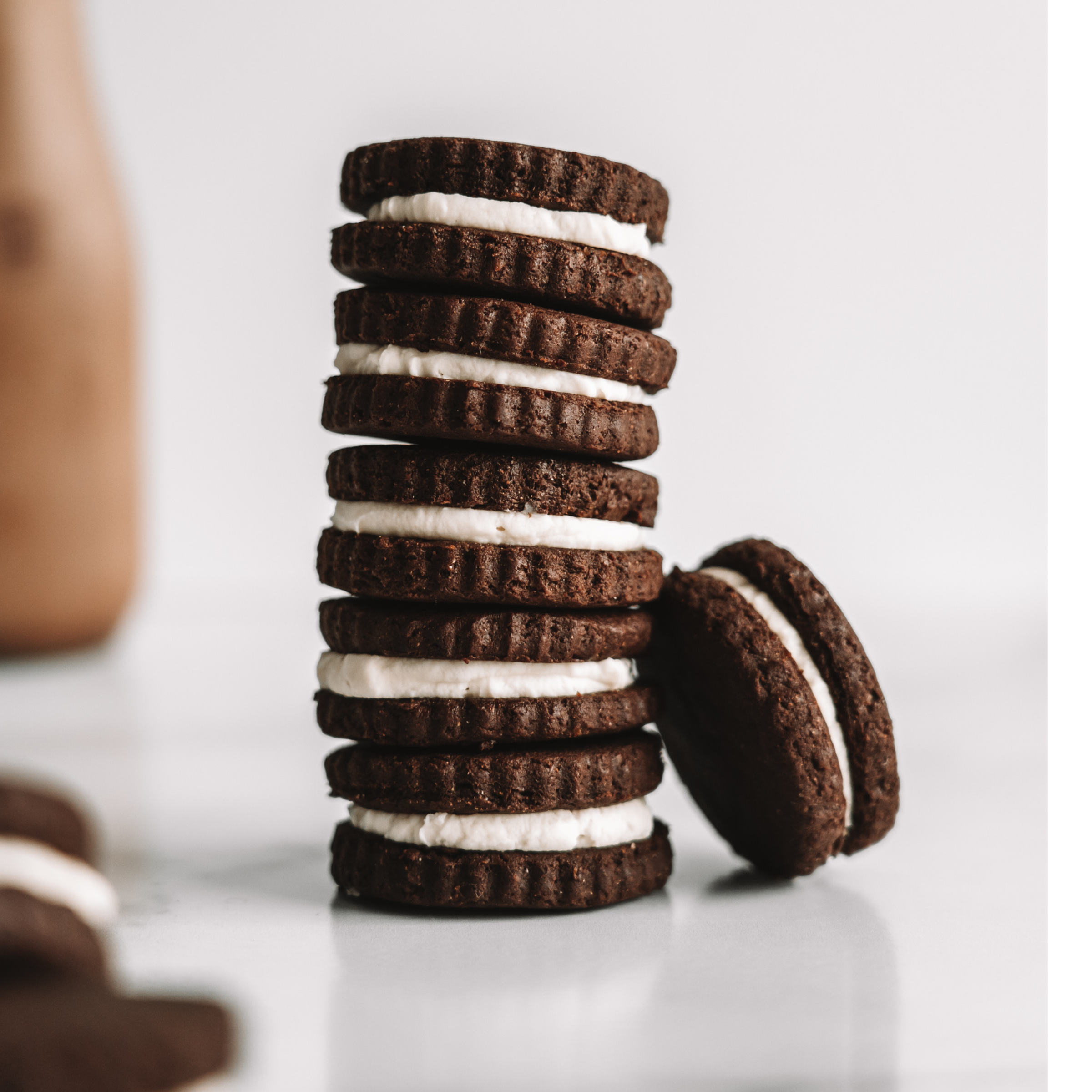 stack of vegan chocolate sandwich cookies and a glass of plant-based chocolate milk