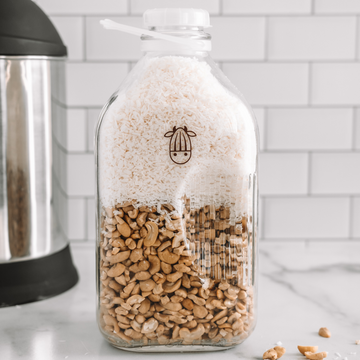 cashews and coconut shreds in a Almond Cow glass jug to make Coconut Cashew Milk