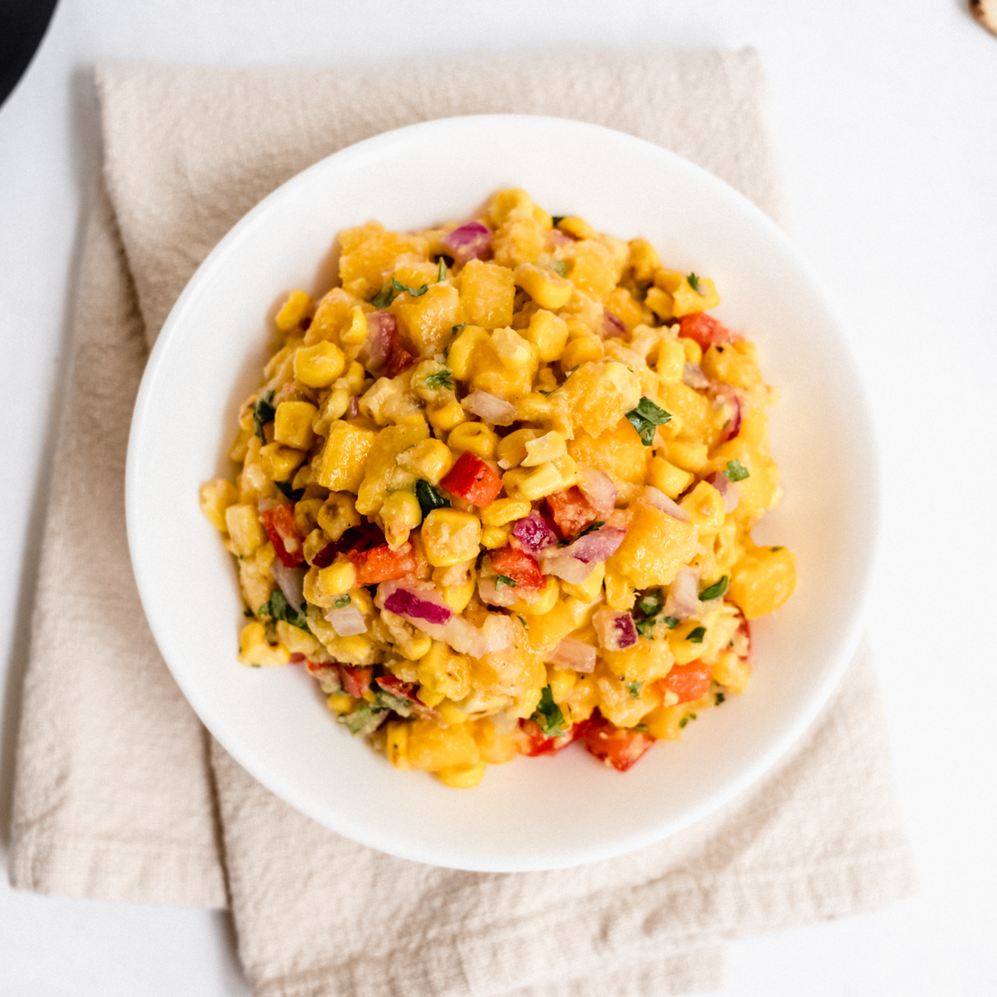 vegan corn and mango salsa with red bell pepper, onion and cilantro in a bowl
