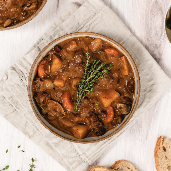 vegan hearty stew in a bowl with bread on the side