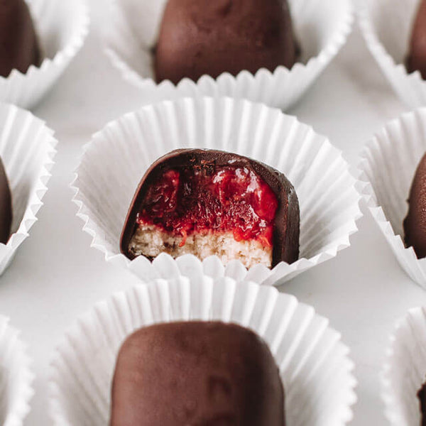a vegan PB&J Truffle with a bite out of it
