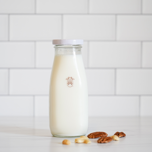vegan, plant-based PeCashew creamer in an almond cow glass bottle