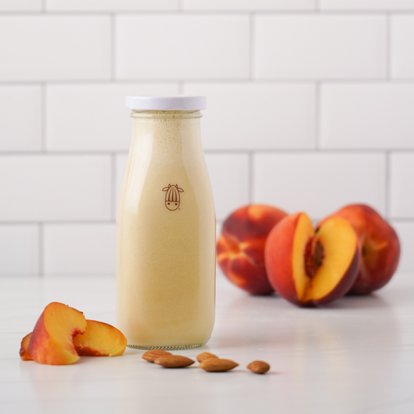 vegan peaches n cream creamer in an almond cow glass bottle