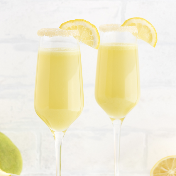 two glasses of vegan pear champagne sparkler garnished with lemon slices