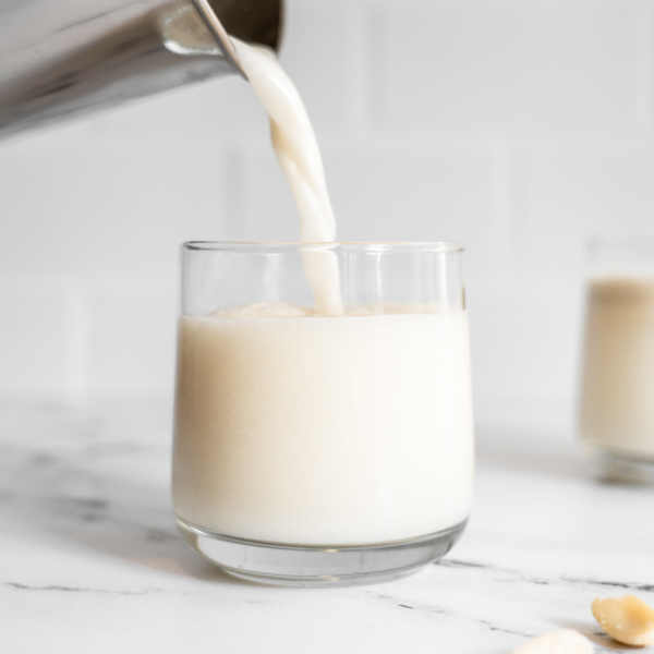 plant-based pili nut milk being poured into a glass