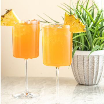Aperol Spritz with pineapple, aperol, and prosecco. 