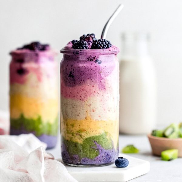 Rainbow fruit smoothie with glass of plant-based milk