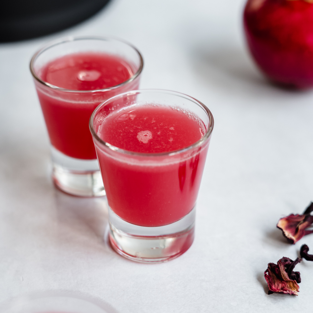 Skin Elixir shot made in the Almond Cow. It's bright red and shown in a shot glass.