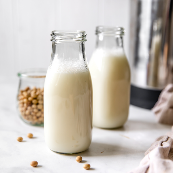 homemade, plant-based, vegan Soy Milk in two small glass bottles