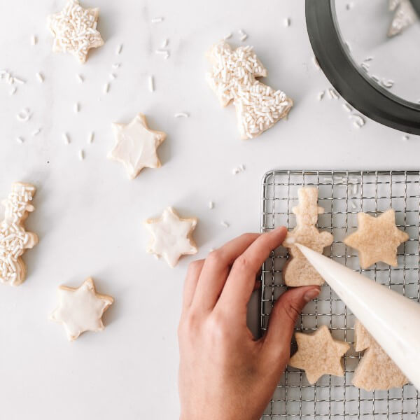 A person decorating vegan sugar cookies