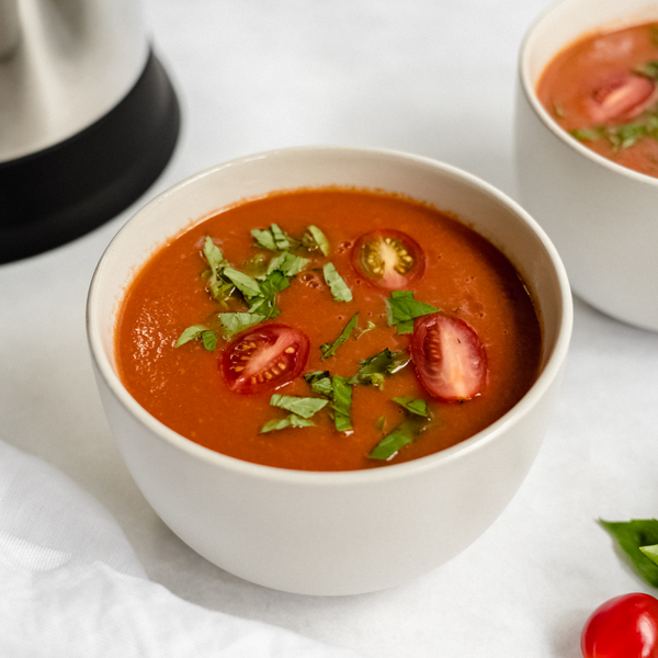 Tomato Bisque in a bowl garnished with tomatoes and fresh basil