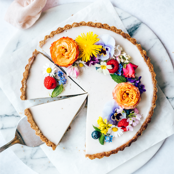 vegan, gluten-free, vanilla panna cotta tart with edible flowers on top