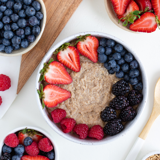a bowl of vegan whole grain oatmeal with berries on top
