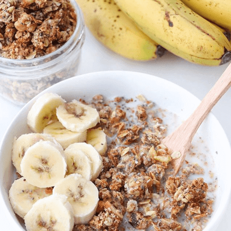 a bowl of homemade almond pulp granola with milk and bananas