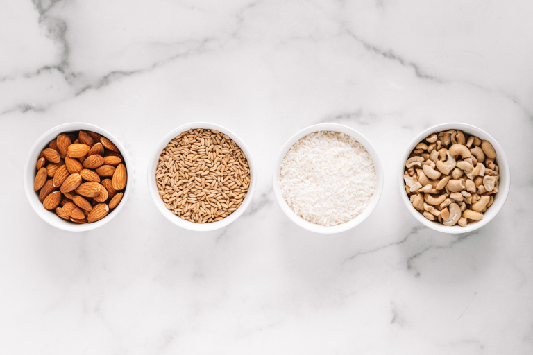 bowls of Almond Cow Ingredients: Almonds, Whole Grain Oats, Coconut shreds, and Cashew Pieces.