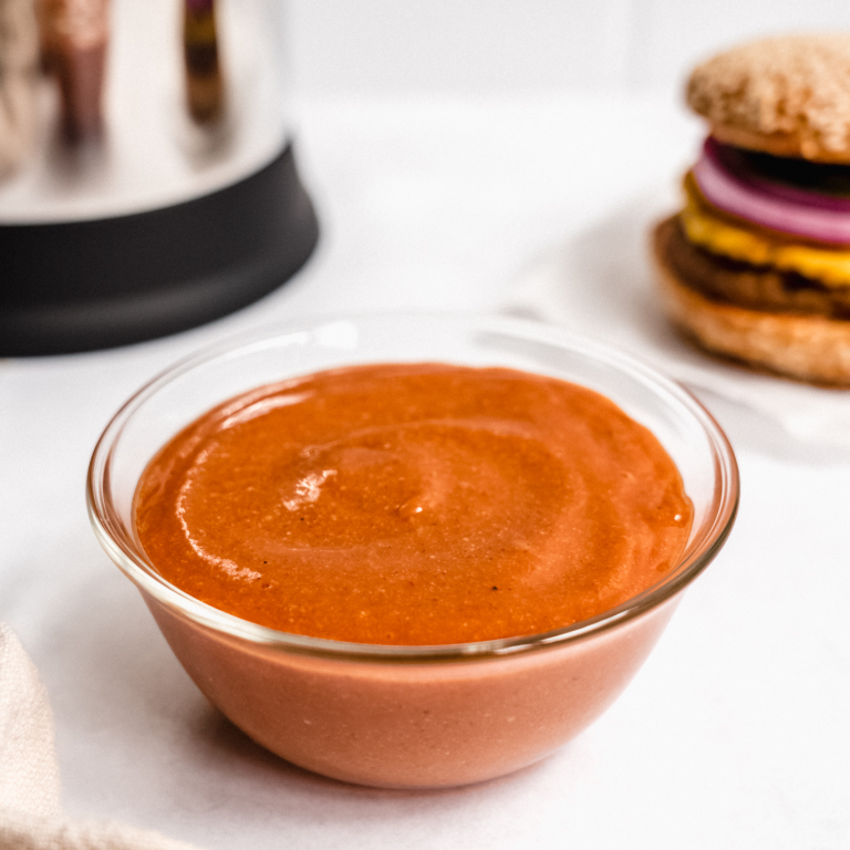 vegan barbeque sauce in a bowl next to an Almond Cow and a vegan burger